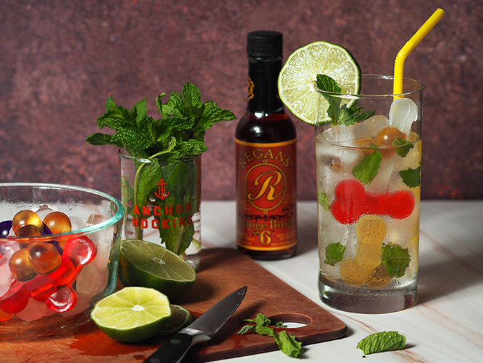 Clear cocktail with mint leaves sitting on a windowsill