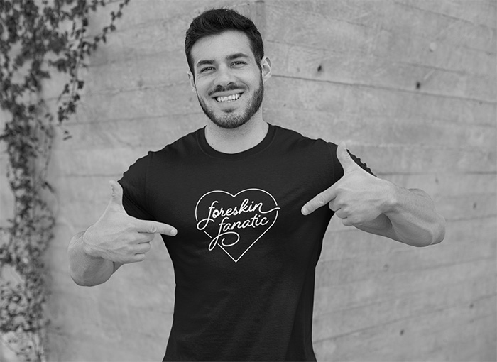 Man pointing to his shirt that says 'foreskin fanatic' in a heart