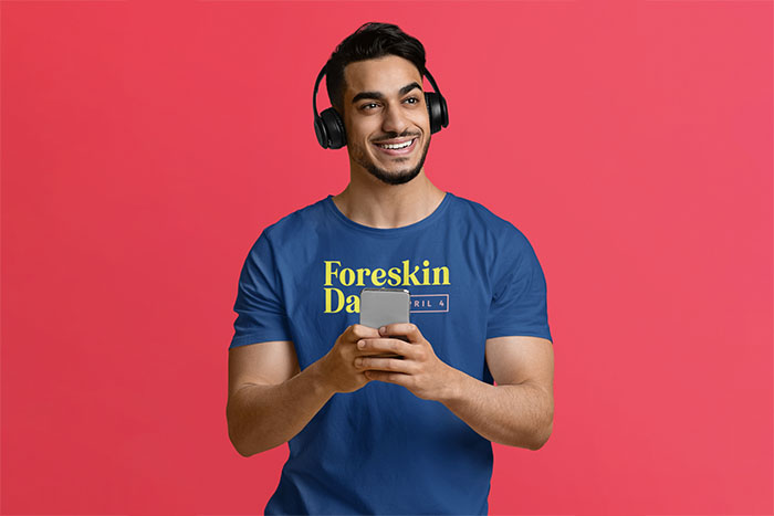 Man with headphones standing in front of a pink background